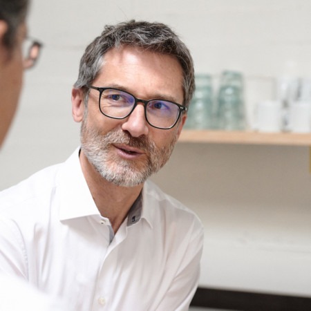 Stephan, Gründer von Valean Solutions, spricht mit einem Kollegen bei einer Tasse Kaffee.